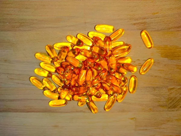 Gelule omega sur fond bois
