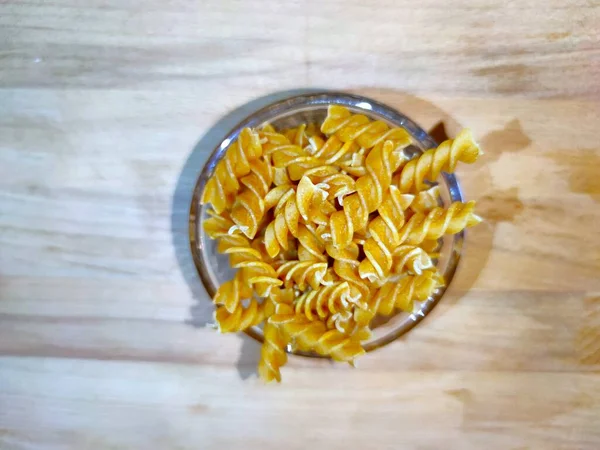 Pates sur fond bois dans rcipient