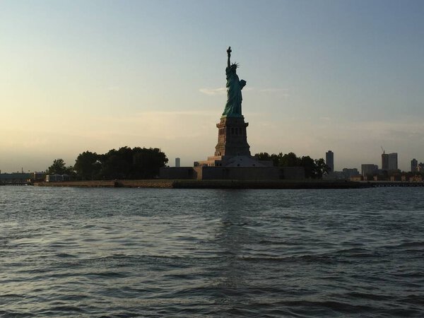 Estatua de la libertad vista desde el rio al atardecer