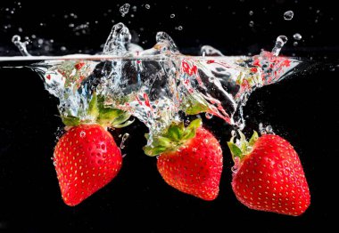 Arka planda üç çilek var.