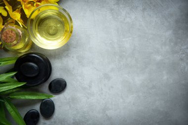Tayland Spa 'sı. Sıcak taşlar masaj için hazırlanıyor ve tahtanın üzerinde sarı orkide ile rahatlıyor. Yaşam Tarzı Sağlıklı Kavram, afiş için kopyalama alanı, üst görünüm