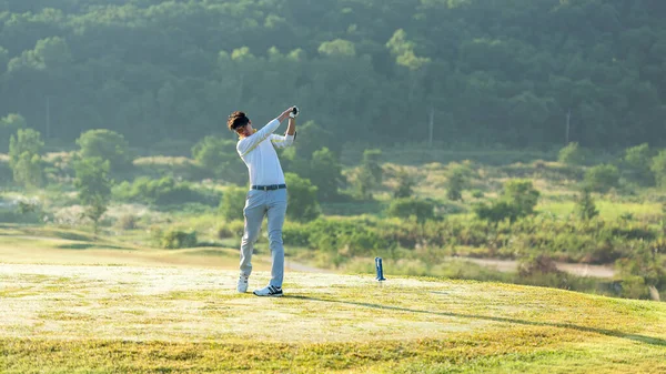 Golfer sport course golf ball fairway. People lifestyle man playing game golf tee off on the green grass. Asian man player game shot in summer.  Healthy and Sport outdoor