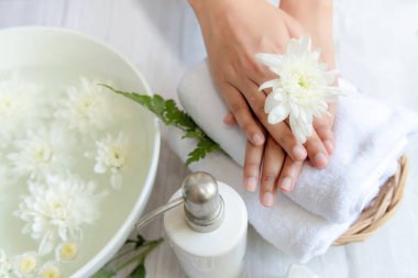 Güzellik masajı sağlık sağlığı. Çivi ve eller için spa Thai terapisi. Beyaz çiçekli kadın. Rahatlamak için mum ve yaz zamanı.
