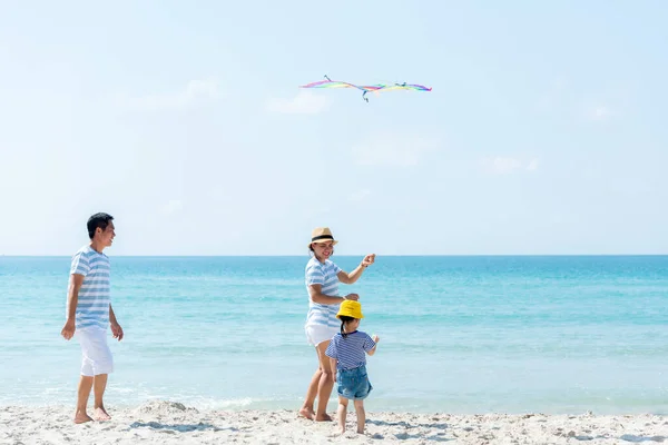 Asian happy family have fun and play kite on the beach.  Family people tourism travel in summer and holiday  for leisure and destination. Travel and Family Concept