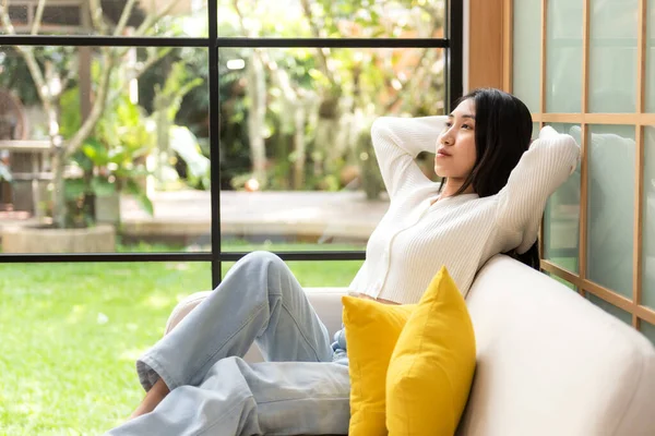 Home lifestyle woman relaxing on sofa in living room. Happy girl lying down on comfortable pillows taking a nap for wellness and health in weekend holiday.  Lifestyle Concept