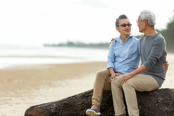 Asian Lifestyle senior couple hug and sitting on the beach happy in love romantic and relax time