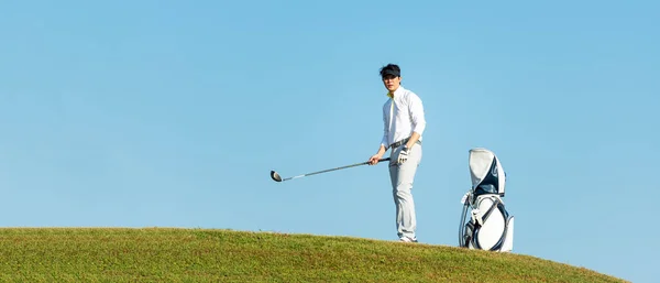 Golfer sport course golf ball fairway. People lifestyle man approach playing game golf tee off on the green grass. Asian man player game shot in summer