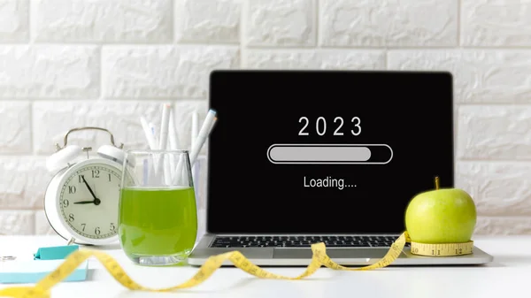 Yeni bir işe başlamak ve yeni bir hayata başlamak için 2023 yılı yükleniyor. Ofiste çalışırken sağlıklı atıştırmalıklar ve ekipman sporu. Diyet için yeşil elma ve taze su Sağlık Planlama