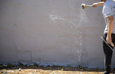 Baskılı beton duvarın yapımında çalışan adam. 