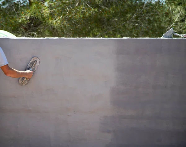 Man working on the construction of the printed concrete wall