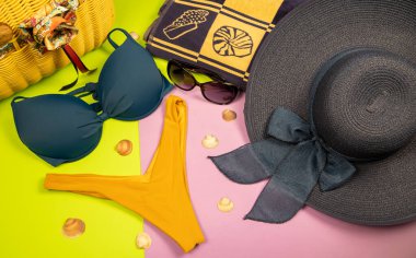 Pastel arka planda plaj aksesuarları. Gözlük, şapka, havlu, fli.