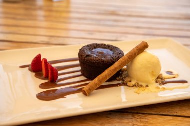 Delicious coulant or chocolate volcano with vanilla and strawberry ice cream