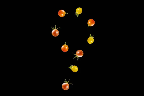 cherry tomatoes of various colors falling in the shape of a numb