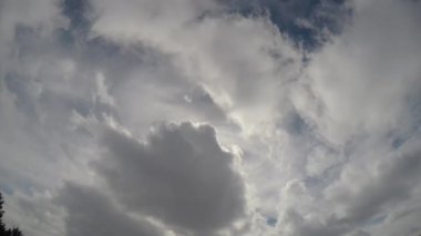 Yüksek ve alçak irtifa bulutlarının birleşimi. Güneş, mavi gökyüzü ve hareket eden bulutlar tarafından yaratılmış ilginç bir manzara. Gökyüzündeki yağmur bulutlarının dansı.