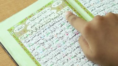 Asya, Pakistan, Hindistan, BAE - 11 Haziran 2022: Kutsal Kur 'an' ın Sûrasını okuyan kız, ahşap arka planda Kur 'an-ı Müsveddesi. Ramazan Kareem kavramı,