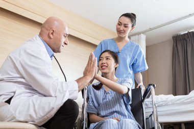 Doktorlar koronavirüs hastalarını muayene ediyor ve hastalara tezahürat yapıyor..