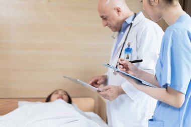 Doktorlar ve tıp öğrencileri yatağında yatan hastaları tedavi ediyor..