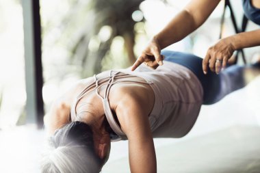 Kıdemli bayan Asya çifti evde birlikte esneme egzersizi yapıyor. Fitness yogası ve sağlıklı yaşam tarzı konsepti