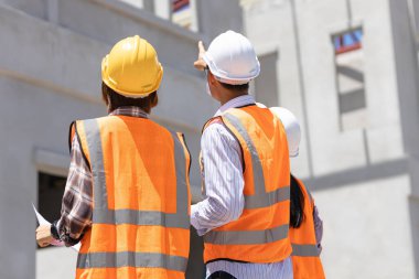 İnşaat mühendisi inşaat alanında mimarla konuşuyor. ya da yüksek binalı şantiyeler