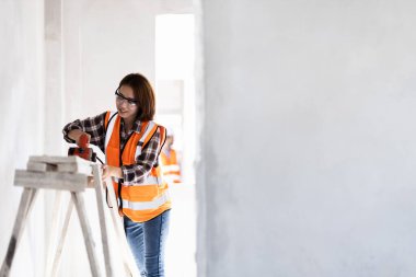 Asyalı kadınlar bir ev inşa etmek için kereste üzerinde çalışıyorlar..