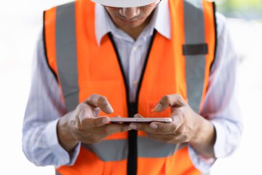 Endüstriyel adam mühendis ile smartphone bir fabrikada portresi çalışma.