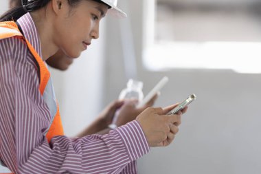 Yetişkinler Mühendis Grubu Koltukta oturan arkadaşlar modern akıllı telefon tabletlerini kullanarak iş arkadaşlığı, takım çalışması, işbirliği kavramını başlatıyorlar.