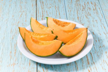 Dilimlenmiş Japon kavunu, ballı kavun ya da ahşap bir masada seramik tabakta kavun..