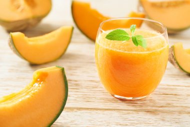 Ahşap bir masada taze kavun ve naneli ev yapımı smoothie. Sağlıklı beslenme kavramı.