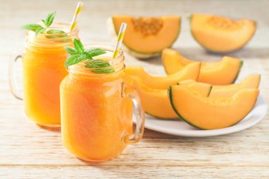 Kavun püresi cam kavanozlarda ve nane arkaplanlı taze kavun. Sağlıklı beslenme kavramı..