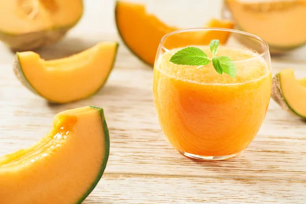 Ahşap bir masada taze kavun ve naneli ev yapımı smoothie. Sağlıklı beslenme kavramı.
