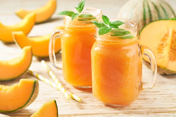 Kavun püresi cam kavanozlarda ve nane arkaplanlı taze kavun. Sağlıklı beslenme kavramı..