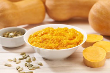 Seramik kasede kabak püresi, taze balkabağı, kabak, tereyağı beyaz mutfak masasına yakın. Balkabağı humusu..