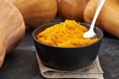 Balkabağı humusu seramik kasede, siyah taş mutfak masasına yakın..