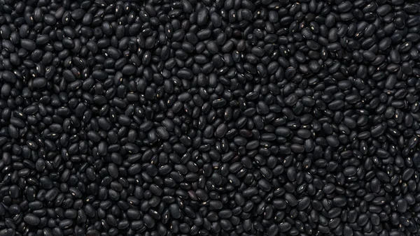 close-up texture of raw black beans (urad dal, black gram, vigna mungo) top view.