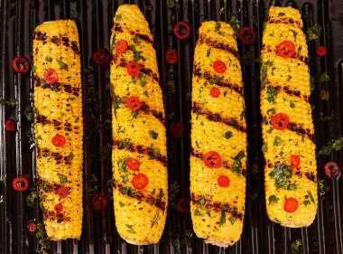 Cooking corn on the grill. top view. Ripe yellow corn is grilled