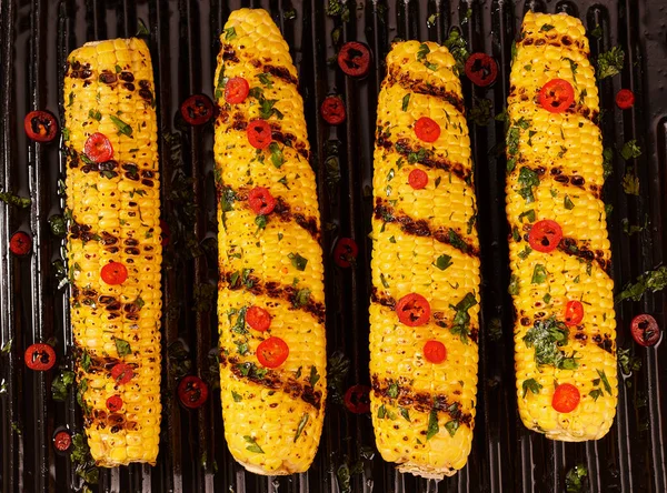 Cooking corn on the grill. top view. Ripe yellow corn is grilled