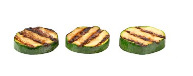 Beyaz arkaplanda ızgara kabak dilimleri var.