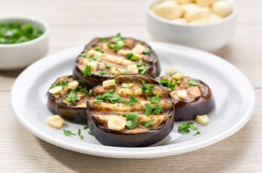 Salad with grilled aubergine, cparsley and garlic on a white bowl, selective focus.  healthy food . vegan or vegetarian food .