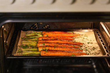 Fırında, yeşil otlu kızarmış havuç, fırında, seçici bir odaklanma..
