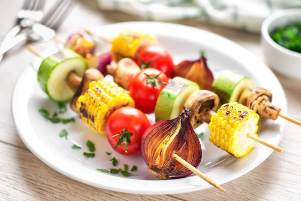 vegetable kebabs on skewers grilled on grill or BBQ on a white table,selective focus. Grilled vegetarian skewers of colorful vegetables.