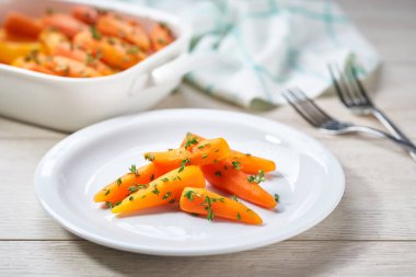 Ev yapımı kavrulmuş ballı havuç kekik yemeye hazır, seçici bir odak noktası. Sağlıklı kök sebze kavramı.