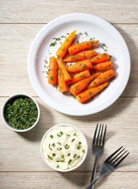 Fırında bal jöleli havuç kekik ile seramik tabakta kremalı sos, üst manzara.