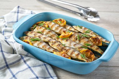 Mavi kare pişirme tepsisinde biberiyeli ve limonlu fırında sardalya, seçici bir odak. Balıklarla Akdeniz diyeti.