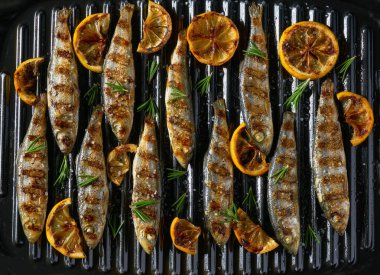 Izgarada ızgara sardalya, biberiye ve limon. Izgara yemek, ızgara balık. Barbekü ve ızgara partileri için fikirler.