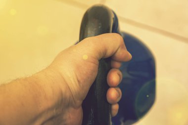 Erkeklerin elindeki demir çaydanlık ahşap bir arka planda. Spor salonunda çan sesleri. Kapatın. Spor salonunda çaydanlık çanı, üst manzara. ses tonlu