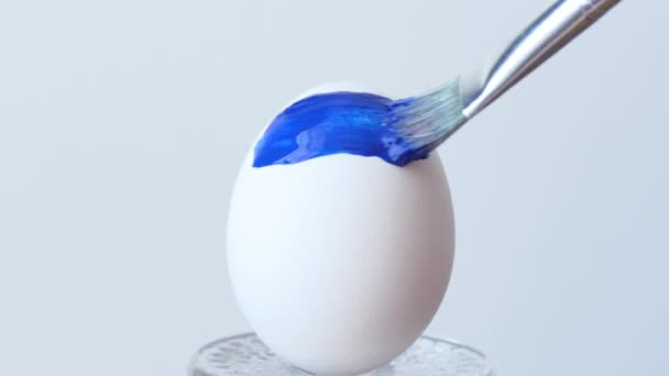 Το κορίτσι ζωγραφίζει πασχαλινά αυγά σε κίτρινο-μπλε χρώμα. Σημαία της Ουκρανίας, ένα σύμβολο σε ένα αυγό του Πάσχα. — Αρχείο Βίντεο