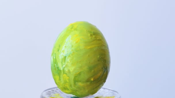 Zbliżenie osoby malującej pisanki specjalnym pędzlem. Dziewczyna maluje jajko wielkanocne żółto-czerwone. Przygotowania do Wielkanocy. Biały stół, zbliżenie. — Wideo stockowe