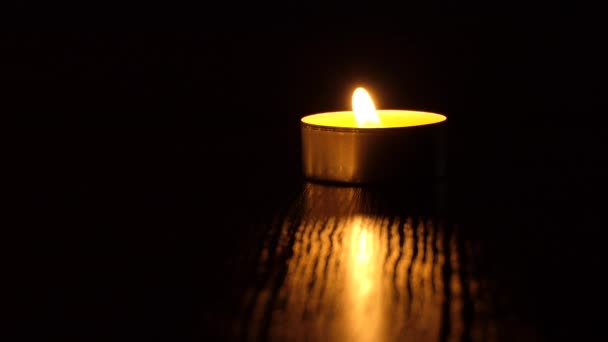 Die Kerze flackert im Dunkeln. Eine weiße runde Kerze brennt auf dunklem Hintergrund. Runde Kerzen brennen und erlöschen. Leid. Romantik. Freude. 4K-Video — Stockvideo