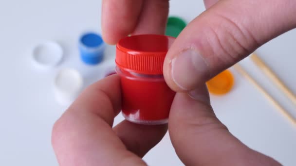 Set gouache paints in bright color jars close-up. A set of multicolored gouache on plastic jars. Hobby of creative drawing. Close-up of red paint with refocus on all colors. — Stock Video