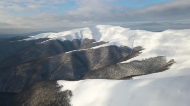 Sisli sıradağlar, çayırlar ve kış mevsiminde karla kaplı tepeler üzerinde inanılmaz bir uçuş. Gymba Dağı, Ukrayna Karpatları. 4k hava görüntüsü.